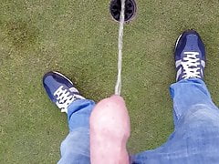Boy takes a piss at the golf course