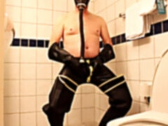 Rubbergloved draining in the motel bathroom wearing waders