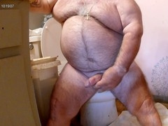 Hairy bear strokes off in the shower and his fur gets covered in cum