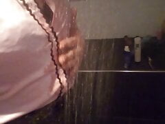 Crossdresser in satijn blouse under the shower