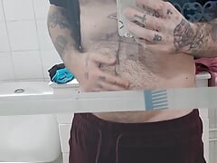 Hairy boy strips naked in front of the mirror and jerks off