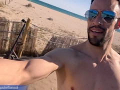 Sporty young man strips naked on a public beach in Barcelona after a gym workout