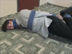 BG Young businessman bound gagged and struggling.