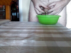 John is peeing into a green bowl on the table