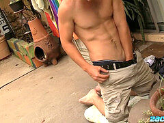 Nerdy youngster Zack Randall with glasses stroking it outdoor