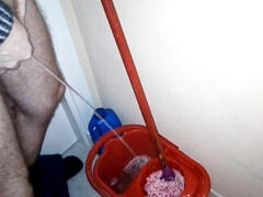 John is taking a piss into the cleaning bucket