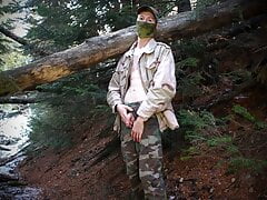 Soldier pisses outdoors in a cold forest in early spring.