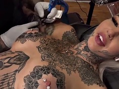 Alternative girls pussy is masturbated during a tattoo session