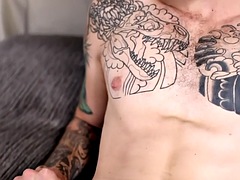 Tattooed stud stroking his hairy shaft during a solo scene