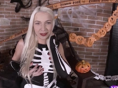 Blonde girl in skeleton costume fingers pussy after reveals tits