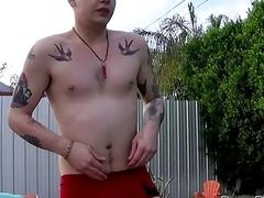 Dashing young jock with tattoos tugs on his cock outdoors