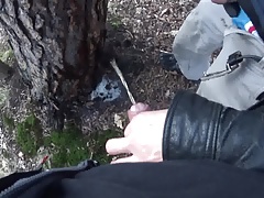 my boyfriend holding my pissing cock outdoor in the woods