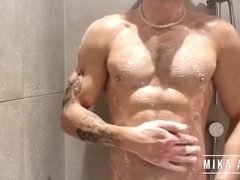 Hot tattooed guy Mika Ayden shows off his abs while dancing in the shower with his big soft cock