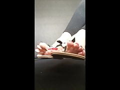 POV soles dangling with leather flip flops and red toe nails