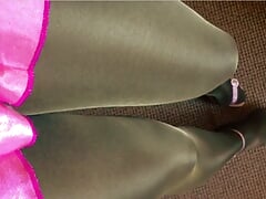 Tanned and black pantyhose layered legs satin pink miniskirt and heeled pink sandals.