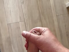 Close-up of young cock squirting on the kitchen table.