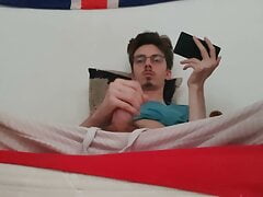 Twink jerks off his big cock and ejaculates while watching a porno