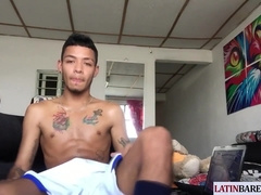 Tattooed slender Latino gets naked and drains on bed