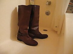 Pissing on brown leather boots in a bathtub
