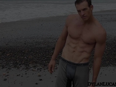 Sexy gay Davey playing hard his massive horny cock by the beach.