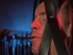 Tied up behind bars and getting his erect cock jerked off