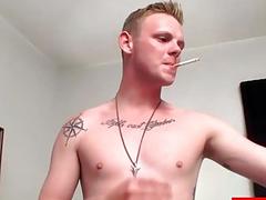 Young stud has a cigarette in one hand and his dick in the other