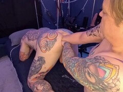 Tattooed guy moaning while indulging in double fisting action