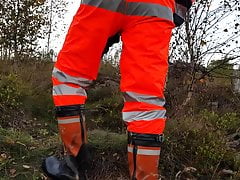 Worker in hiviz rain gear and rubber boots