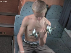 Blond guy jerks off lying in a camper van