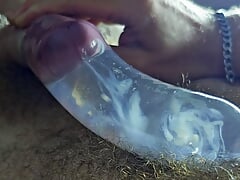 The guy cums in a condom with hot water with powerful volleys