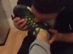 Cara lambendo o tenis de 2 amigos