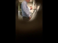 Guys in the urinals taking leak.