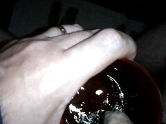 John is taking a piss in his coffee mug